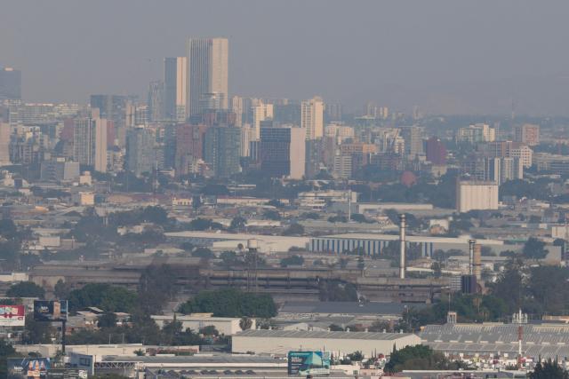 This aerial view shows buildings amid air pollution in Guadalajara, Mexico on February 5, 2026. Lower blood oxygenation, greater physical exertion and increased ball speed are the challenges that Mexico City's altitude of 2,240 metres presents to the footballers who will play at the Azteca Stadium during the 2026 FIFA World Cup. (Photo by ULISES RUIZ / AFP)