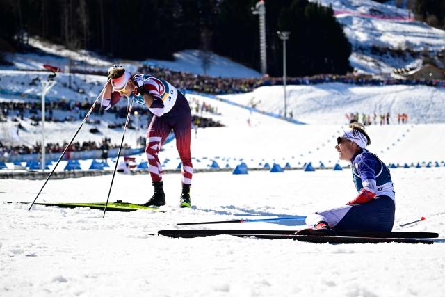 Austria's Benjamin Moser (L) and France's Victor Lovera react after crossing the finish line during the men's 10km cross-country interval start free event of the Milano Cortina 2026 Winter Olympic Games at Tesero Cross-Country Skiing Stadium in Lago di Tesero (Val di Fiemme) on February 13, 2026. (Photo by Tobias SCHWARZ / AFP)