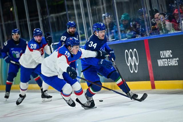 Slovakia's #15 Dalibor Dvorsky (L) fights for the puck with Italy's #34 Tommy Purdeller during the men's preliminary round Group B Ice Hockey match between Italy and Slovakia at the Milano Rho Ice Hockey Arena at the Milano Cortina 2026 Winter Olympic Games in Milan, on February 13, 2026. (Photo by JULIEN DE ROSA / AFP)