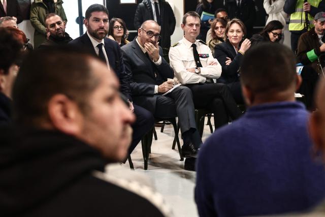 France's Interior Minister Laurent Nunez (C) flanked by France's Housing Minister Vincent Jeanbrun (C-L) and Prefect of Marseille Jacques Witkowski (C-R) listen to association members at the ZEF theater to discuss prevention and urban policy during his visit to Marseille, southern France on February 13, 2026. (Photo by Thibaud MORITZ / AFP)