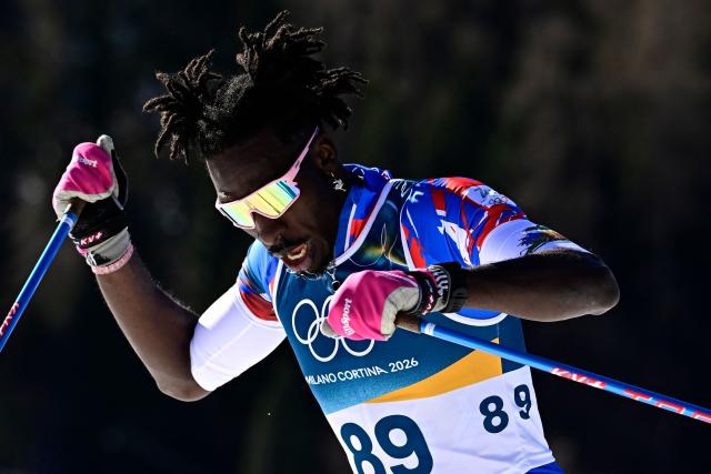 Haiti's Stevenson Savart reacts after crossing the finish line during the men's 10km cross-country interval start free event of the Milano Cortina 2026 Winter Olympic Games at Tesero Cross-Country Skiing Stadium in Lago di Tesero (Val di Fiemme) on February 13, 2026. (Photo by Tobias SCHWARZ / AFP)