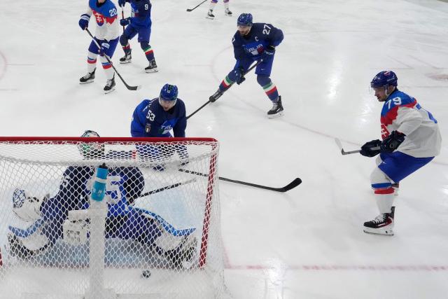 Slovakia's #79 Libor Hudacek (R) shoots and scores his team first goal during the men's preliminary round Group B Ice Hockey match between Italy and Slovakia at the Milano Rho Ice Hockey Arena at the Milano Cortina 2026 Winter Olympic Games in Milan, on February 13, 2026. (Photo by Darko Bandic / POOL / AFP)