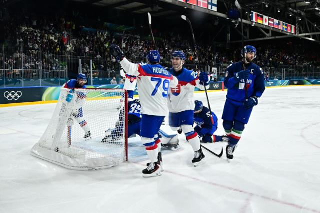 Slovakia's #79 Libor Hudacek (C) celebrates with Slovakia's #20 Juraj Slafkovsky (2nd R)  after scoring his team first goal during the men's preliminary round Group B Ice Hockey match between Italy and Slovakia at the Milano Rho Ice Hockey Arena at the Milano Cortina 2026 Winter Olympic Games in Milan, on February 13, 2026. (Photo by JULIEN DE ROSA / AFP)