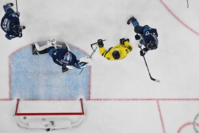 Sweden's #14 Joel Eriksson Ek (2nd R) reacts as Finland's #74 Juuse Saros (2nd L) concedes a goal  during the men's preliminary round Group B Ice Hockey match between Finland and Sweden at the Milano Santagiulia Ice Hockey Arena during the Milano Cortina 2026 Winter Olympic Games in Milan, on February 13, 2026. (Photo by Alexander NEMENOV / AFP)
