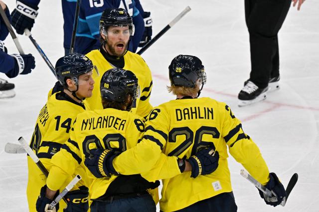 Sweden's #26 Rasmus Dahlin (R) celebrates with teammates  after scoring a goal  during the men's preliminary round Group B Ice Hockey match between Finland and Sweden at the Milano Santagiulia Ice Hockey Arena during the Milano Cortina 2026 Winter Olympic Games in Milan, on February 13, 2026. (Photo by Alexander NEMENOV / AFP)