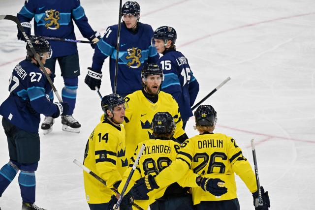 Sweden's #26 Rasmus Dahlin (R) celebrates with teammates  after scoring a goal  during the men's preliminary round Group B Ice Hockey match between Finland and Sweden at the Milano Santagiulia Ice Hockey Arena during the Milano Cortina 2026 Winter Olympic Games in Milan, on February 13, 2026. (Photo by Alexander NEMENOV / AFP)