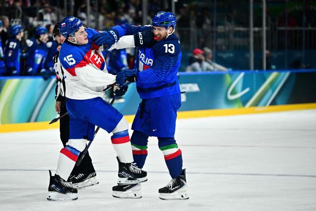 Slovakia's #15 Dalibor Dvorsky (L) fights with Italy's #13 Matt Bradley during the men's preliminary round Group B Ice Hockey match between Italy and Slovakia at the Milano Rho Ice Hockey Arena at the Milano Cortina 2026 Winter Olympic Games in Milan, on February 13, 2026. (Photo by JULIEN DE ROSA / AFP)