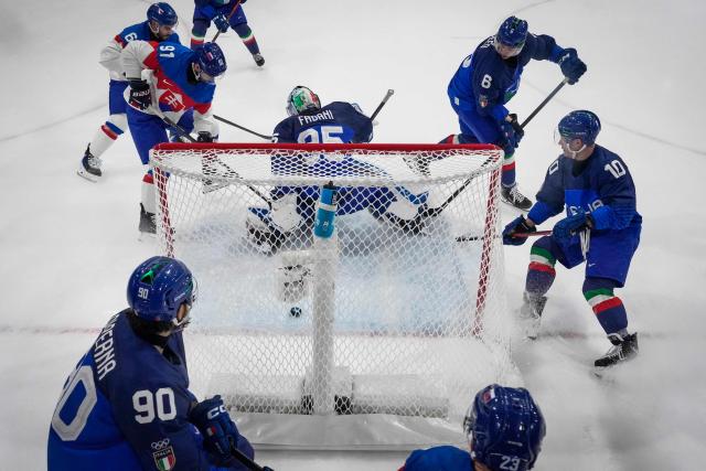 Slovakia's #91 Matus Sukel (rear L) shoots and scores his team second goal past Italy's #35 Davide Fadani during the men's preliminary round Group B Ice Hockey match between Italy and Slovakia at the Milano Rho Ice Hockey Arena at the Milano Cortina 2026 Winter Olympic Games in Milan, on February 13, 2026. (Photo by Darko Bandic / POOL / AFP)