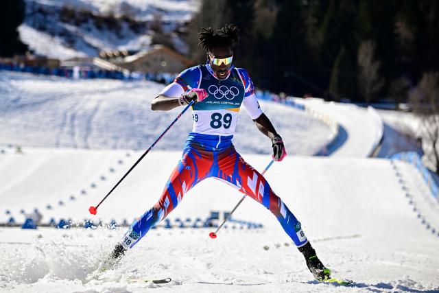Haiti's Stevenson Savart reacts after crossing the finish line during the men's 10km cross-country interval start free event of the Milano Cortina 2026 Winter Olympic Games at Tesero Cross-Country Skiing Stadium in Lago di Tesero (Val di Fiemme) on February 13, 2026. (Photo by Tobias SCHWARZ / AFP)