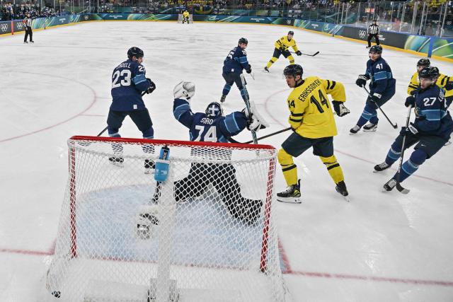 Sweden's #26 Rasmus Dahlin (C rear) scores a goal past Finland's #74 Juuse Saros (2nd L)  during the men's preliminary round Group B Ice Hockey match between Finland and Sweden at the Milano Santagiulia Ice Hockey Arena during the Milano Cortina 2026 Winter Olympic Games in Milan, on February 13, 2026. (Photo by Alexander NEMENOV / POOL / AFP)