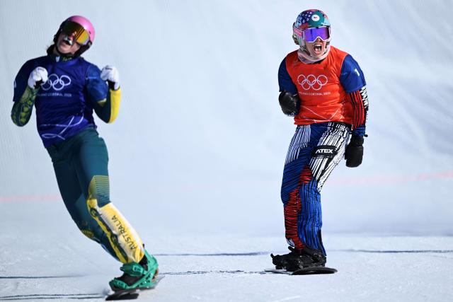 Australia's Josie Baff and Czech Republic's Eva Adamczykova (R) react as they finish first and second in the snowboard women's cross semi final 1 during the Milano Cortina 2026 Winter Olympic Games at Livigno Snow Park, in Livigno (Valtellina), on February 13, 2026. (Photo by Kirill KUDRYAVTSEV / AFP)