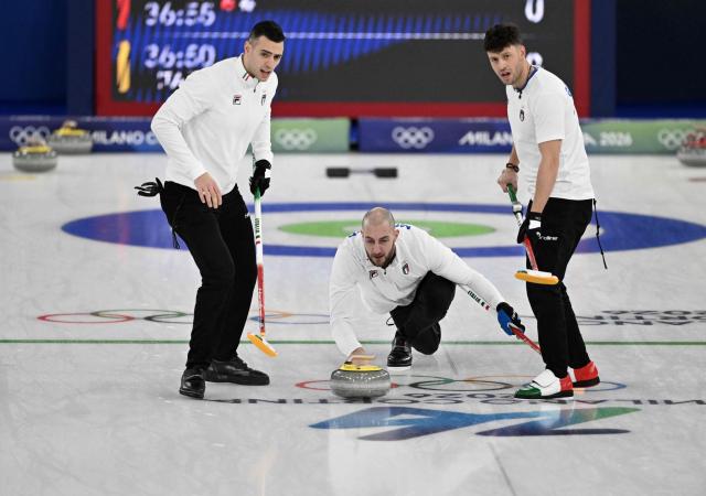 Mattia Giovannella (R), Sebastiano Arman (L) and Amos Mosaner (C) of Team Italy compete in the curling men's round robin between Britain and Italy during the Milano Cortina 2026 Winter Olympic Games at the Cortina Curling Olympic Stadium in Cortina d’Ampezzo on February 13, 2026. (Photo by Tiziana FABI / AFP)