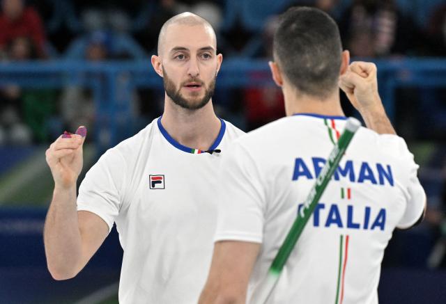 Mattia Giovanella (R) and Amos Mosaner of Team Italy celebrate after winning their match against Great Britain in the curling men's round robin between Britain and Italy during the Milano Cortina 2026 Winter Olympic Games at the Cortina Curling Olympic Stadium in Cortina d’Ampezzo on February 13, 2026. (Photo by Tiziana FABI / AFP)