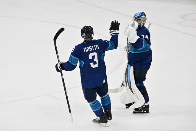 Finland's #03 Olli Maatta (L) and Finland's #74 Juuse Saros celebrate after winning the men's preliminary round Group B Ice Hockey match between Finland and Sweden at the Milano Santagiulia Ice Hockey Arena during the Milano Cortina 2026 Winter Olympic Games in Milan, on February 13, 2026. (Photo by Alexander NEMENOV / AFP)
