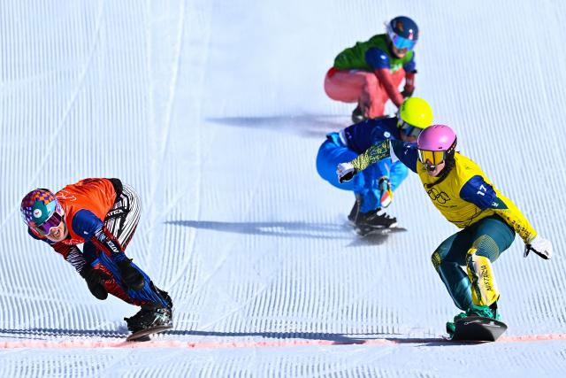 Australia's Josie Baff (R) crosses the finish-line ahead of Czech Republic's Eva Adamczykova (L), Switzerland's Noemie Wiedmer (rear) and Italy's Michela Moioli in the snowboard women's cross final during the Milano Cortina 2026 Winter Olympic Games at Livigno Snow Park, in Livigno (Valtellina), on February 13, 2026. (Photo by Kirill KUDRYAVTSEV / AFP)