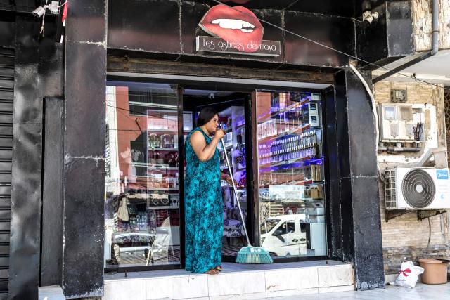An employee cleans the entrance of the adult store “Les astuces de Maya” on the eve of Valentine’s Day in Dakar, on February 13, 2026. (Photo by PATRICK MEINHARDT / AFP)