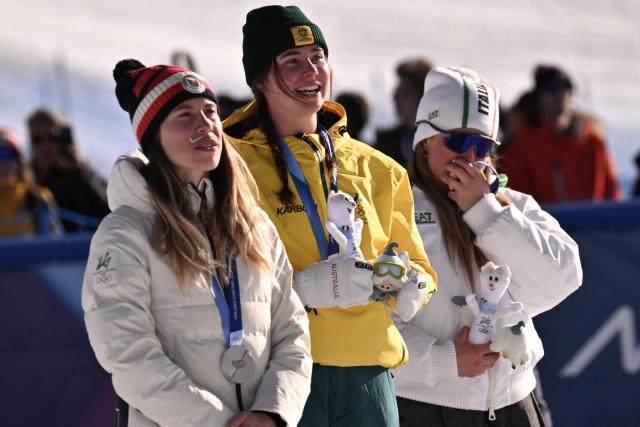 (From L) Silver medallist Czech Republic's Eva Adamczykova, gold medallist Australia's Josie Baff and bronze medallist Italy's Michela Moioli pose on the podium after the snowboard women's cross final during the Milano Cortina 2026 Winter Olympic Games at Livigno Snow Park, in Livigno (Valtellina), on February 13, 2026. (Photo by Jeff PACHOUD / AFP)