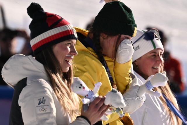 (From L) Silver medallist Czech Republic's Eva Adamczykova, gold medallist Australia's Josie Baff and bronze medallist Italy's Michela Moioli react on the podium after the snowboard women's cross final during the Milano Cortina 2026 Winter Olympic Games at Livigno Snow Park, in Livigno (Valtellina), on February 13, 2026. (Photo by Jeff PACHOUD / AFP)