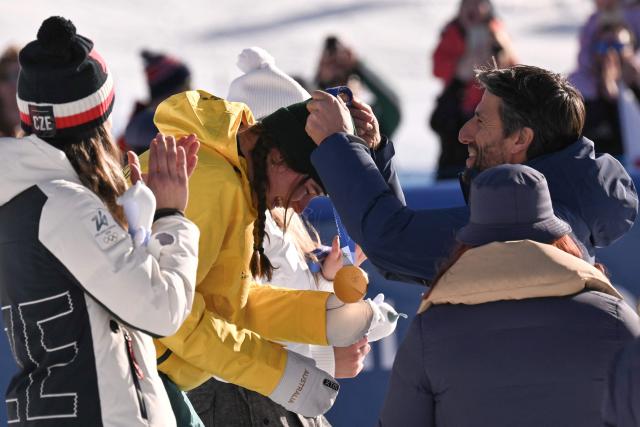 International Olympic Committee (IOC) member and former French canoeist Tony Estanguet (R) presents the gold medal to Australia's Josie Baff (C) on the podium after the snowboard women's cross final during the Milano Cortina 2026 Winter Olympic Games at Livigno Snow Park, in Livigno (Valtellina), on February 13, 2026. (Photo by Jeff PACHOUD / AFP)