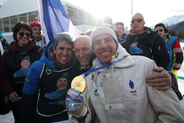 Gold medalist France's Quentin Fillon Maillet (R) poses with his parents after the podium ceremony of the men's biathlon 10km sprint event during the Milano Cortina 2026 Winter Olympic Games at the Anterselva Biathlon Arena (Sudtirol Arena) in Anterselva (Val Pusteria) on February 13, 2026. (Photo by FRANCK FIFE / AFP)