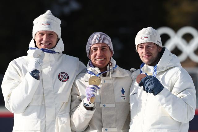 (From L) Silver medalist Norway's Vetle Sjaastad Christiansen, gold medalist France's Quentin Fillon Maillet and bronze medalist Norway's Sturla Holm Laegreid pose on the podium of the men's biathlon 10km sprint event during the Milano Cortina 2026 Winter Olympic Games at the Anterselva Biathlon Arena (Sudtirol Arena) in Anterselva (Val Pusteria) on February 13, 2026. (Photo by FRANCK FIFE / AFP)