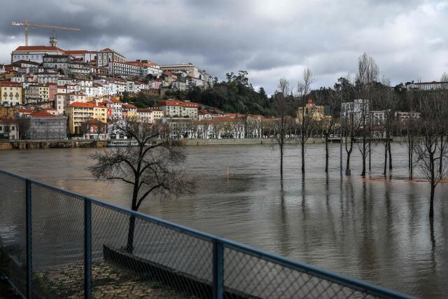 The swollen Mondego river is pictured in Coimbra on February 13, 2026. In the city of Coimbra, central Portugal, authorities fear a 'one-hundred-year flood' of the Mondego River, which could inundate downtown neighborhoods, according to the municipality as it prepared today for potential preemptive evacuations (Photo by PATRICIA DE MELO MOREIRA / AFP)