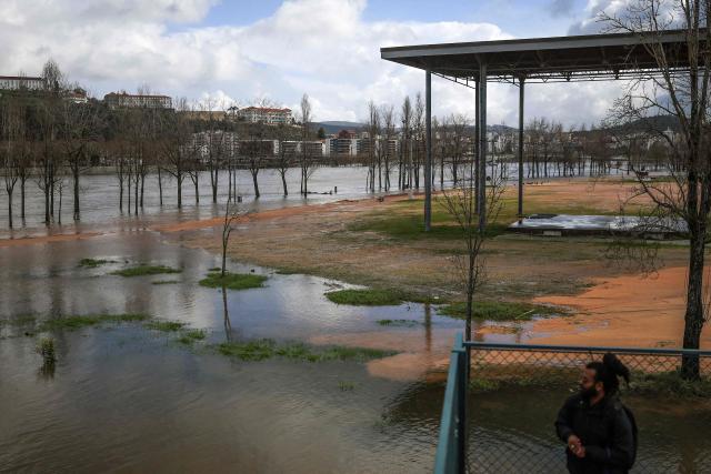 The swollen Mondego river is pictured in Coimbra on February 13, 2026. In the city of Coimbra, central Portugal, authorities fear a 'one-hundred-year flood' of the Mondego River, which could inundate downtown neighborhoods, according to the municipality as it prepared today for potential preemptive evacuations (Photo by PATRICIA DE MELO MOREIRA / AFP)