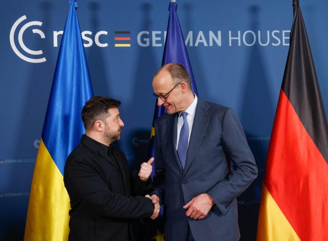 Ukrainian President Volodymyr Zelensky (L) and German Chancellor Friedrich Merz pose prior bilateral talks during the 62nd Munich Security Conference (MSC) on February 13, 2026 in Munich, southern Germany. Heads of state and government as well as foreign and defence ministers from all over the world are expected to attend the security policy talks from February 13 to 15, 2026. (Photo by Michaela STACHE / POOL / AFP)