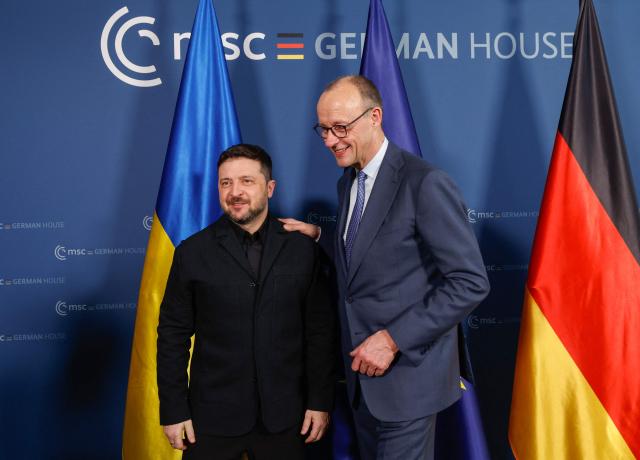 Ukrainian President Volodymyr Zelensky (L) and German Chancellor Friedrich Merz pose prior bilateral talks during the 62nd Munich Security Conference (MSC) on February 13, 2026 in Munich, southern Germany. Heads of state and government as well as foreign and defence ministers from all over the world are expected to attend the security policy talks from February 13 to 15, 2026. (Photo by Michaela STACHE / POOL / AFP)