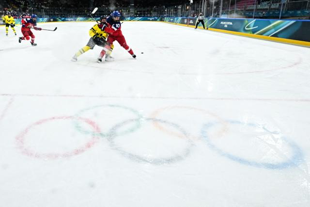 Czech Republic's #10 Denisa Krizova (R) fights for the puck with Sweden's #09 Jessica Adolfsson during the women's quarter final Ice Hockey match between Czech Republic and Sweden at the Milano Rho Ice Hockey Arena at the Milano Cortina 2026 Winter Olympic Games in Milan, on February 13, 2026. (Photo by JULIEN DE ROSA / AFP)