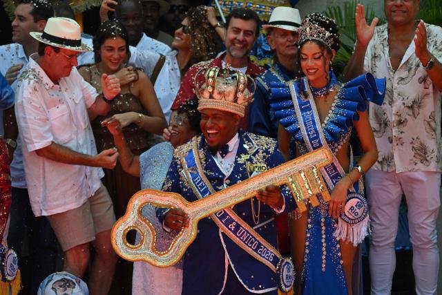 King Momo Cedric da Costa receives the key of the city from Rio de Janeiro Mayor Eduardo Paes (L) during the official Carnival opening ceremony in Rio de Janeiro, Brazil, on February 13, 2026. (Photo by Mauro PIMENTEL / AFP)