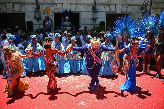 King Momo Cedric da Costa (2-R) and Queen of the Carnival Caroline Xavier of Unidos da Tijuca acknowledge the crowd during the official Carnival opening ceremony in Rio de Janeiro, Brazil, on February 13, 2026. (Photo by Mauro PIMENTEL / AFP)