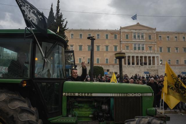 A Greek farmer flashes a peace sign with his fingers as farmers protest with tractors outside Greek parliament during a demonstration in Athens on February 13, 2026. (Photo by Angelos TZORTZINIS / AFP)