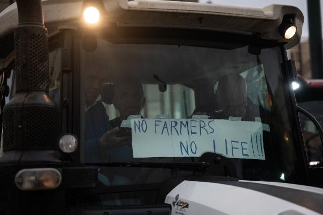 Greek farmers sit on a tractor as they protest with tractors outside Greek parliament during a demonstration in Athens on February 13, 2026. (Photo by Angelos TZORTZINIS / AFP)