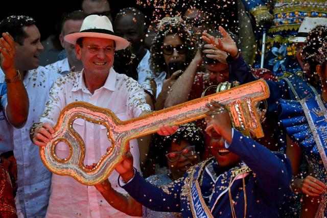 King Momo Cedric da Costa (R) receives the key of the city from Rio de Janeiro Mayor Eduardo Paes (L) during the official Carnival opening ceremony in Rio de Janeiro, Brazil, on February 13, 2026. (Photo by Mauro PIMENTEL / AFP)