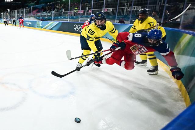 Sweden's #55 Jenna Raunio (L) body checks Czech Republic's #08 Tereza Pistekova as they fight for the puck during the women's quarter final Ice Hockey match between Czech Republic and Sweden at the Milano Rho Ice Hockey Arena at the Milano Cortina 2026 Winter Olympic Games in Milan, on February 13, 2026. (Photo by JULIEN DE ROSA / AFP)