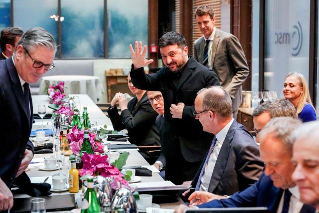 British Prime Minister Keir Starmer (L),  Finnish President Alexander Stubb, Ukrainian President Volodymyr Zelensky (waving), German Chancellor Friedrich Merz (4thR), Polish Prime Minister Donald Tusk and Norwegian Prime Minister Jonas Gahr Store (R) attend a so-called "Berliner Format " meeting at the Munich Security Conference, on February 13, 2026 in Munich. Heads of state and government as well as foreign and defence ministers from all over the world are expected to attend the security policy talks from February 13 to 15, 2026. (Photo by Kay Nietfeld / POOL / AFP)