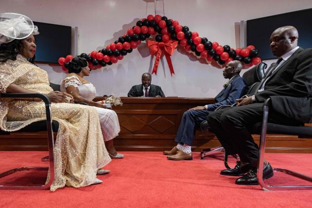 Couples sit in front of the commissioner for Civil Registration at the National Identification and Registration Authority (NIRA) in Kampala, Uganda, on February 13, 2026. Fourteen couples, including Ugandans, Congolese, and Eritreans, participated in a special Valentine's Day event organized by NIRA, held a day early due to the agency's closure on Saturday. (Photo by Badru Katumba / AFP)