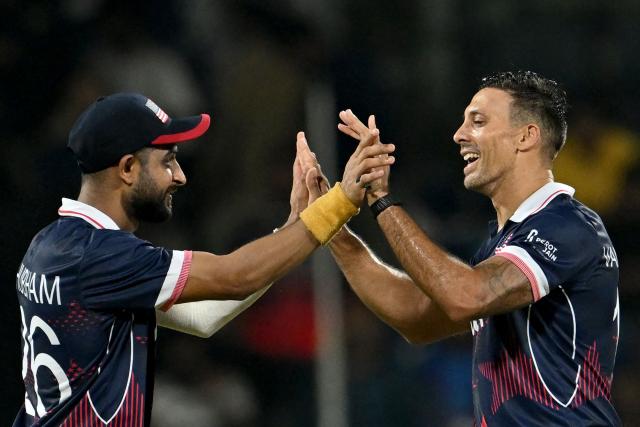 USA's Shadley van Schalkwyk (R) celebrates with teammate after taking the wicket of Netherlands' Aryan Dutt during the 2026 ICC Men's T20 Cricket World Cup group stage match between Netherlands and USA at MA Chidambaram Stadium in Chennai on February 13, 2026. (Photo by R. Satish BABU / AFP)