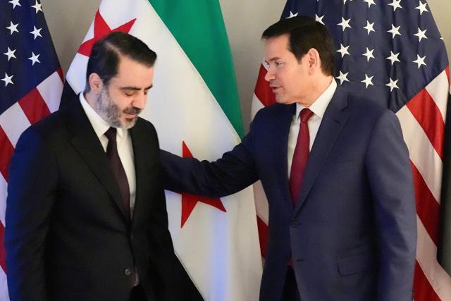 US Secretary of State Marco Rubio (R) and Syrian Foreign Minister Asaad al-Shibani meet on the sidelines of the Munich Security Conference, on February 13, 2026 in Munich. Heads of state and government as well as foreign and defence ministers from all over the world are expected to attend the security policy talks from February 13 to 15, 2026. (Photo by Alex Brandon / POOL / AFP)