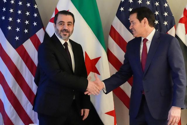 US Secretary of State Marco Rubio (R) and Syrian Foreign Minister Asaad al-Shibani shake hands as they met on the sidelines of the Munich Security Conference, on February 13, 2026 in Munich. Heads of state and government as well as foreign and defence ministers from all over the world are expected to attend the security policy talks from February 13 to 15, 2026. (Photo by Alex Brandon / POOL / AFP)