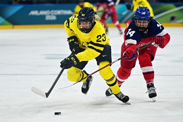 Sweden's #23 Thea Johansson (L) fights for the puck with Czech Republic's #14 Dominika Laskova during the women's quarter final Ice Hockey match between Czech Republic and Sweden at the Milano Rho Ice Hockey Arena at the Milano Cortina 2026 Winter Olympic Games in Milan, on February 13, 2026. (Photo by JULIEN DE ROSA / AFP)