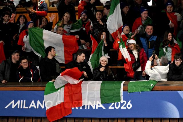 Italian supporters cheer during the curling men's round robin between Great Britain and Italy at the Milano Cortina 2026 Winter Olympic Games at the Cortina Curling Olympic Stadium in Cortina d’Ampezzo on February 13, 2026. (Photo by Tiziana FABI / AFP)
