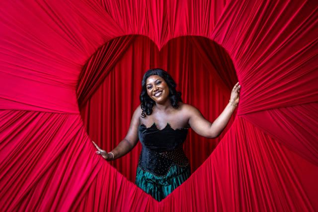 (FILES) A patron poses for a photograph with a heart-shaped photo box at The Locale restaurant in Lagos, on February 8, 2026. In the run-up to this year's Valentine's Day on February 14, 2026, romantics from Paris to Lagos and in the ongoing Olympic Games, are preparing to celebrate the Roman Saint Valentine whose feast day has since the Middle Ages been associated with courting couples. (Photo by OLYMPIA DE MAISMONT / AFP)