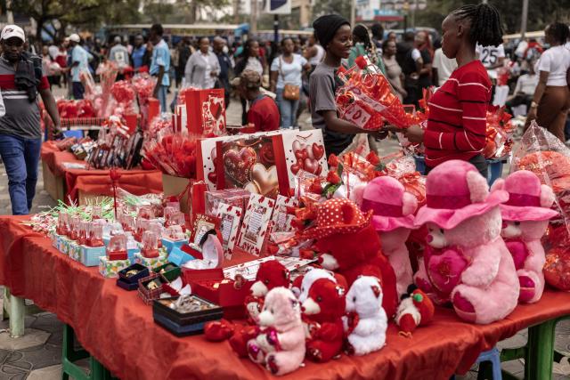 A pedestrian (R) buys from a vendor a Valentine Day gift  in downtown Nairobi, on February 13, 2026. (Photo by SIMON MAINA / AFP)