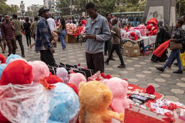 A pedestrians looks to buy as vendors sell Valentine Day gifts in downtown Nairobi, on February 13, 2026. (Photo by SIMON MAINA / AFP)