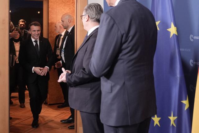 France's President Emmanuel Macron (L) arrives to attend a trilateral meeting with Germany's Chancellor Friedrich Merz (R) and Britain's Prime Minister Keir Starmer (C) during the Munich Security Conference in Germany on February 13, 2026. (Photo by Stefan Rousseau / POOL / AFP)