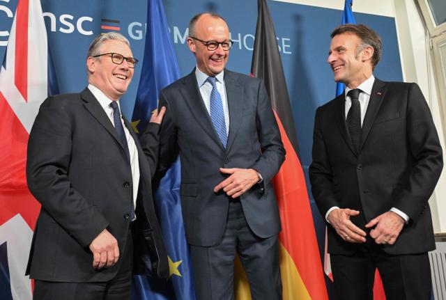 (L-R) British Prime Minister Keir Starmer, German Chancellor Friedrich Merz and France’s President Emmanuel Macron pose at the start of the E-3 meeting, during the Munich Security Conference, on February 13, 2026 in Munich. Heads of state and government as well as foreign and defence ministers from all over the world are expected to attend the security policy talks from February 13 to 15, 2026. (Photo by THOMAS KIENZLE / POOL / AFP)