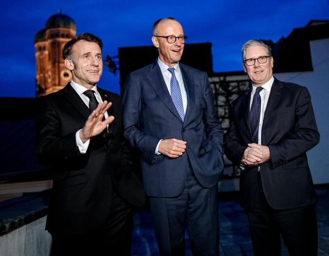 German Chancellor Friedrich Merz, France’s President Emmanuel Macron and Keir Starmer, Prime Minister of the United Kingdom stand together at the start of the E-3 meeting, during the Munich Security Conference, on February 13, 2026 in Munich. Heads of state and government as well as foreign and defence ministers from all over the world are expected to attend the security policy talks from February 13 to 15, 2026. (Photo by Kay Nietfeld / POOL / AFP)