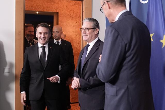 France's President Emmanuel Macron (L) arrives to attend a trilateral meeting with Germany's Chancellor Friedrich Merz (R) and Britain's Prime Minister Keir Starmer (C) during the Munich Security Conference in Germany on February 13, 2026. (Photo by Stefan Rousseau / POOL / AFP)